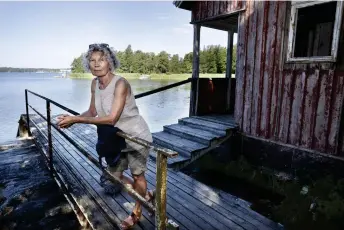  ??  ?? – Nybondas är extremt viktigt för mig, säger Kati Salminen, som bott i Nordsjö i tio år. Hon passerar Villa Notsunds nedgångna strandbast­u på väg till sitt morgondopp på Notholmen.