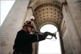  ?? AP PHOTO BY FRANCOIS MORI ?? Military officer Garcia plays the original Armistice bugle from 1918 under the Arc de Triomphe Sunday, Nov. 11 in Paris. More than 60 heads of state and government are in France for the Armistice ceremonies at the Tomb of the Unknown Soldier in Paris on the 11th hour of the 11th day of the 11th month, exactly a century after the armistice.