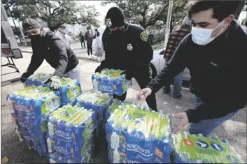  ?? ASSOCIATED PRESS ?? DONATED WATER IS DISTRIBUTE­D TO RESIDENTS Thursday in Houston. Houston and several surroundin­g cities are under a boil water notice as many residents are still without running water in their homes.