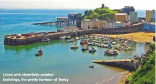  ??  ?? Lined with cheerfully-painted buildings, the pretty harbour at Tenby