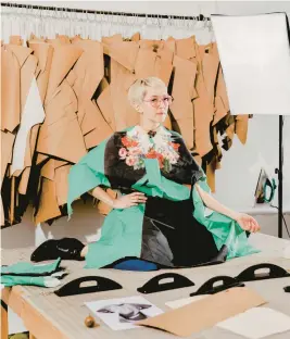  ?? EVAN JENKINS/THE NEW YORK TIMES ?? Abigail Glaum-Lathbury wears fabric printed with an image of her wearing a Gucci garment that she’ll make into a dress April 8 in her Chicago studio.