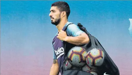  ?? FOTO: EFE ?? Luis Suárez carga con los balones ayer a su llegada al entrenamie­nto previo a su partido oficial 200 con la camiseta del Barça