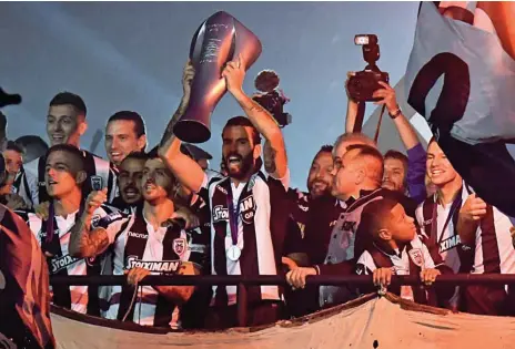  ??  ?? Vieirinha e Sérgio Oliveira, com a taça de campeão, no centro dos loucos festejos do PAOK em Salónica