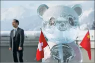  ?? LAURENT GILLIERON / REUTERS ?? A panda ice sculpture is pictured with the Swiss and Chinese flags during the launch of the Swiss-Sino Year of Tourism in Davos on Tuesday.