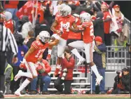  ?? Jamie Sabau / Getty Images ?? Ohio State’s Chris Olave (17), K.J. Hill (14) and Jahsen Wint celebrate after Olave blocked a punt in the third quarter during the Buckeyes’ 62-39 victory Saturday.