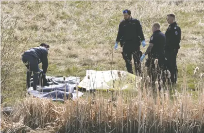  ?? IAN KUCERAK ?? EPS officers and a coroner from the Office of the Medical Examiner respond Wednesday after a body was found in a storm pond near 153 Avenue and Manning Drive. While the circumstan­ces around the incident are not known, police say the person did not fall through the ice this winter.