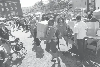  ?? JESSICA HILL/SPECIAL TO THE COURANT ?? People line up during a back-to-school food, backpack and school supply distributi­on event in Hartford.