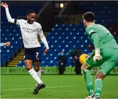  ?? — AFP ?? New dance steps: Manchester City’s Raheem Sterling (left) scores his team’s second goal in the 2-0 win over Burnley on Wednesday.