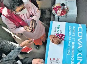  ??  ?? A priest performs a prayer on a box containing Bharat Biotech's anti-covid-19 vaccine Covaxin at a vaccine centre in Jaipur on Wednesday.