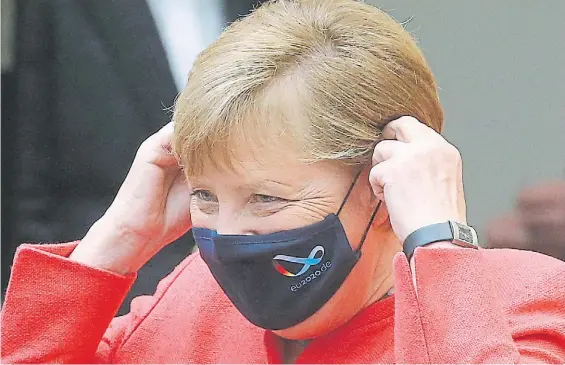  ?? DPA ?? Presencia. La canciller Angela Merkel se quita la máscara antes de pronunciar su discurso en el Bundestag, el Parlamento alemán.