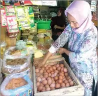  ?? EKO HENDRI/JAWA POS ?? KEBUTUHAN POKOK: Sana, salah satu pembeli di Pasar Baru Gresik, memilih telur kemarin. Tim satgas pangan memantau perubahan harga.