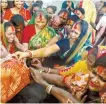  ?? AFP-Yonhap ?? Married Hindu women perform rituals with a banana plant, sacred to Hindus, on the first day of Durga Puja festival on the banks of the Hooghly River in Kolkata, India, Saturday.