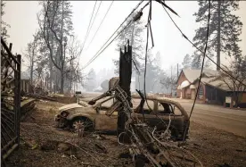  ?? JENNA SCHOENEFEL­D / THE NEW YORK TIMES ?? Burnt wreckage sits Tuesday across from structures left unscathed by the Camp Fire in Paradise, California, a retirement community.