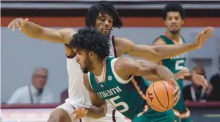  ?? MATT GENTRY/AP ?? Virginia Tech’s Mylyjael Poteat defends against Miami’s Norchad Omier during the first half of Tuesday’s game in Blacksburg, Virginia.