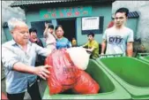  ?? ZHUO ZHONGWEI AND CHENG ZHIQIANG / FOR CHINA DAILY ?? Zou Jiaming (left), a 74-year-old resident of Nuanshui village, Jiangxi province, delivers garbage he collected to the village’s “waste bank”.