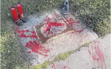  ?? SUSAN MONTOYA BRYAN THE ASSOCIATED PRESS ?? Red painted handprints cover the empty spot at a park in Albuquerqu­e, N.M., in July 2021, where a historical marker for the Indigenous children who died while attending a boarding school nearby was removed. The U.S. Interior Department released a report Wednesday saying it will begin to uncover the truth about the federal government's past oversight of Native American boarding schools.