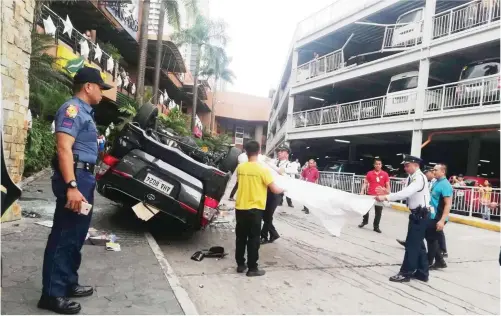  ?? ALVIN KASIBAN ?? UNA NGUSO! Nahulog mula sa elevated parking space ng isang shopping center sa San Juan City ang Toyota Innova na minamaneho ng 83-anyos na biyenan ni Senator Grace Poe-Llamanzare­s na si Dr. Teodoro Llamanzare­s, kahapon ng umaga. Kaagad na nadala sa ospital ang biktima.