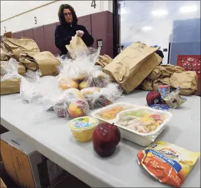  ?? Hearst Connecticu­t Media file photo ?? Volunteer Connie Begetis, of Stamford, bags up meals to distribute to families in Stamford on April 17.