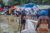  ?? RICHARD PIERRIN/GETTY IMAGES ?? A woman works on a shelter after being hit by Tropical Storm Grace at an improvised refugee camp at Parc Lande de Gabion stadium on Tuesday in Les Cayes, Haiti, after a 7.2-magnitude earthquake struck the country on Saturday.