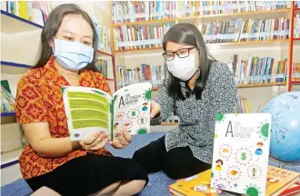  ?? RIANA SETIAWAN/ JAWA POS ?? BERKARYA: Carolina Andahara (kanan) dan Irine Maybanda membaca buku karya siswa SD Gloria 2 kemarin.