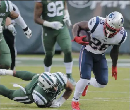  ?? SETH WENIG - THE ASSOCIATED PRESS ?? New England Patriots’ Sony Michel (26) breaks a tackle by New York Jets’ Frankie Luvu (50) during the second half of an NFL football game Sunday, Nov. 25, 2018, in East Rutherford, N.J.