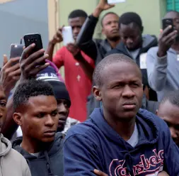  ??  ?? Migranti Alcuni giovani richiedent­i asilo Un africano ha appena ottenuto la protezione umanitaria