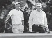  ?? [AP PHOTO] ?? Tiger Woods, left, and Phil Mickelson share a laugh on the 11th tee box while playing a practice round for the Masters golf tournament at Augusta National Golf Club in Augusta, Ga., on Tuesday.