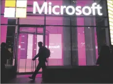  ?? AP PHOTO/SWAYNE B. HALL ?? People walk past a Microsoft office in New York on Nov. 10, 2016.