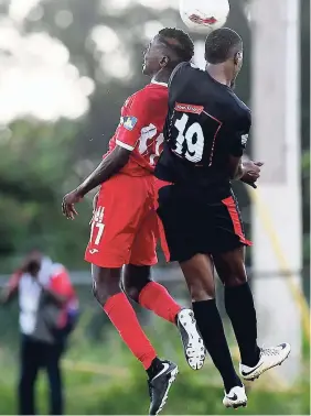  ?? GLADSTONE TAYLOR ?? Shaquille Bradford (left) of Boys’ Town FC goes airborne with Arnett Gardens FC’s Tamar Edwards for possession of the ball in the Red Stripe Premier League match-up at Barbican Field on Thursday.