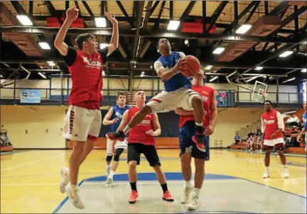  ?? TIM PHILLIS — THE NEWS-HERALD ?? The Blue team’s Jerry Higgins (VASJ) goes to the basket against the Red team in the 40th News-Herald Classic on March 31 at Lakeland Community College.