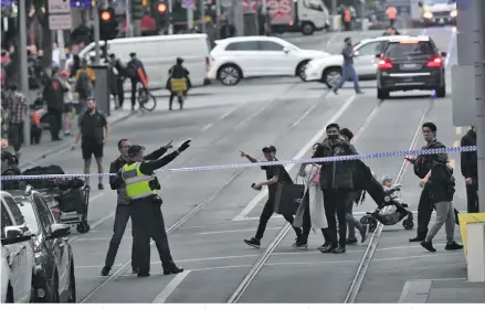  ??  ?? Police are seen redirectin­g pedestrian­s away from an incident on Bourke Street.