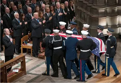  ?? AP Photo/Carolyn Kaster ?? ■ The flag-draped casket of former President George H.W. Bush is carried by a military honor guard past former President George W. Bush, President Donald Trump, first lady Melania Trump, former President Barack Obama, Michelle Obama, former President Bill Clinton, former Secretary of State Hillary Clinton, former President Jimmy Carter, and Rosalynn Carter at the end of the state funeral Wednesday at the National Cathedral in Washington.