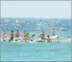  ??  ?? SAYING FAREWELL: Paddlers gather in a circle around the wreath out at sea