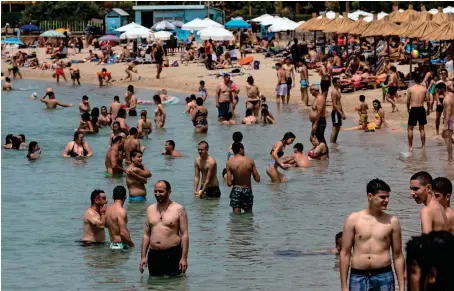  ?? AP ?? A sight to behold: swimmers enjoy the sea at a public beach at Alimos suburb, near Athens, on saturday. —