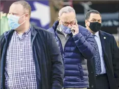  ?? Mary Altaffer / Associated Press ?? Senate Minority Leader Charles Schumer, D-N.Y., center, is surrounded by security as he arrives for a news conference Tuesday in New York.