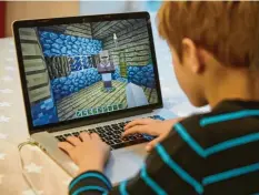  ?? Foto: Georg Wendt, dpa ?? Der neunjährig­e Mingus spielt auf einem Laptop das Open-World-Computersp­iel Minecraft: Jungen haben ein deutlich höheres Suchtrisik­o.