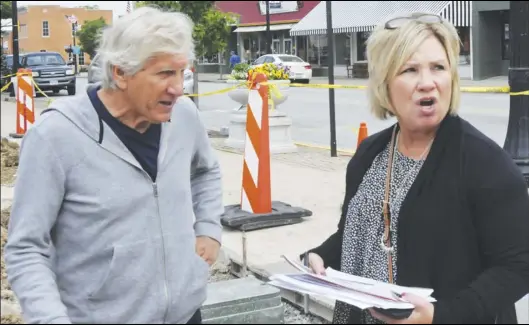  ??  ?? Artist David Lepo and First on the Moon President Deb Fisscher confer about the art installati­on planned for the new parking area at the corner of Perry and Auglaize streets in downtown Wapakoneta.