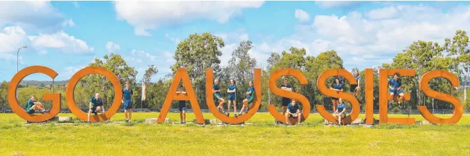  ??  ?? Students from Helensvale State High School check out the giant steel letters Villawood Properties has erected in support of homegrown athletes competing in the Commonweal­th Games.