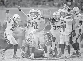  ?? Phelan M. Ebenhack Associated Press ?? THE CHARGERS CELEBRATE a stop against Jacksonvil­le on Sunday. Their run defense has made significan­t improvemen­t since the first five games.