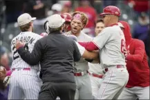  ?? AP photo ?? The Phillies’ Bryce Harper is held back in the seventh inning of a 4-0 loss to the Rockies on Sunday.