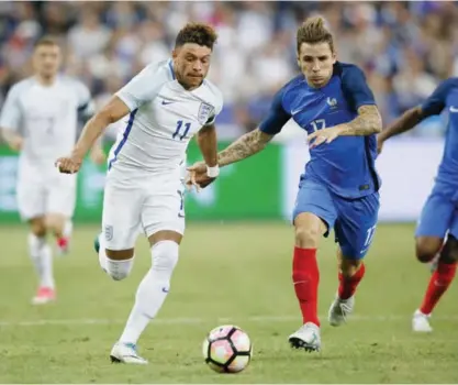  ??  ?? SAINT DENIS: England’s Alex Oxlade-Chamberlai­n, left, outruns France’s Lucas Digne during their friendly soccer match between France and England at the Stade de France in Saint Denis, north of Paris, France, Tuesday. —AP