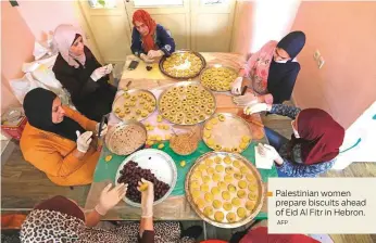  ?? AFP ?? Palestinia­n women prepare biscuits ahead of Eid Al Fitr in Hebron.