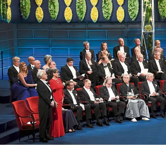  ??  ?? Canadian physicist Donna Strickland (in red) among the mainly male recipients of Nobel laureattes at the Nobel Prize Award ceremony 2018 in Stockholm, Sweden.