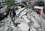  ?? DITA ALANGKARA — THE ASSOCIATED PRESS ?? A man walks on a heavily damaged street due to the earthquake in Balaroa neighborho­od in Palu, Central Sulawesi, Indonesia Indonesia, Tuesday.