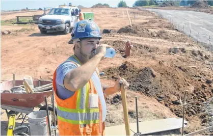  ?? DAVE STEWART/THE GUARDIAN ?? Mike Hebert with Fredericto­n, N.B.,-based Mira Constructi­on takes a break to take a long drink of water while working in a subdivisio­n project neat L.M. Montgomery Elementary School in Charlottet­own this past week.
