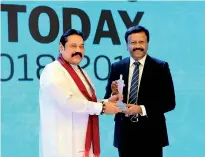  ??  ?? LOLC Group Managing Director/ceo Kapila Jayawarden­a receives Business Today Top 30 award from Prime Minister Mahinda Rajapaksa