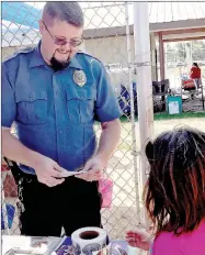  ??  ?? Goodman Police Chief Curt Drake hands out Junior Deputy badges during the Ozark Orchard Festival on Saturday.