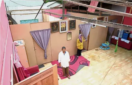  ?? — Bernama ?? Force of nature: A couple surveying the damage to their home after the roof of the house was blown off and damaged during the storm in Kampung Wai, Kuala Perlis.