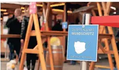 ?? FOTO: DAVID YOUNG/DPA ?? Ein blaues Schild mit dem Aufschrift „Zutritt nur mit Mundschutz“hängt vor einem Restaurant in der Düsseldorf­er Altstadt.