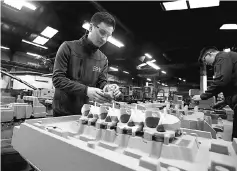  ??  ?? Apprentice Tom Tarr works with a sand mould of a car engine ready for casting at GW cast in Bridgnorth, Britain. The European Union cannot yet assess how much Britain should be asked to pay Brussels when it quits the bloc, as much will have to be...